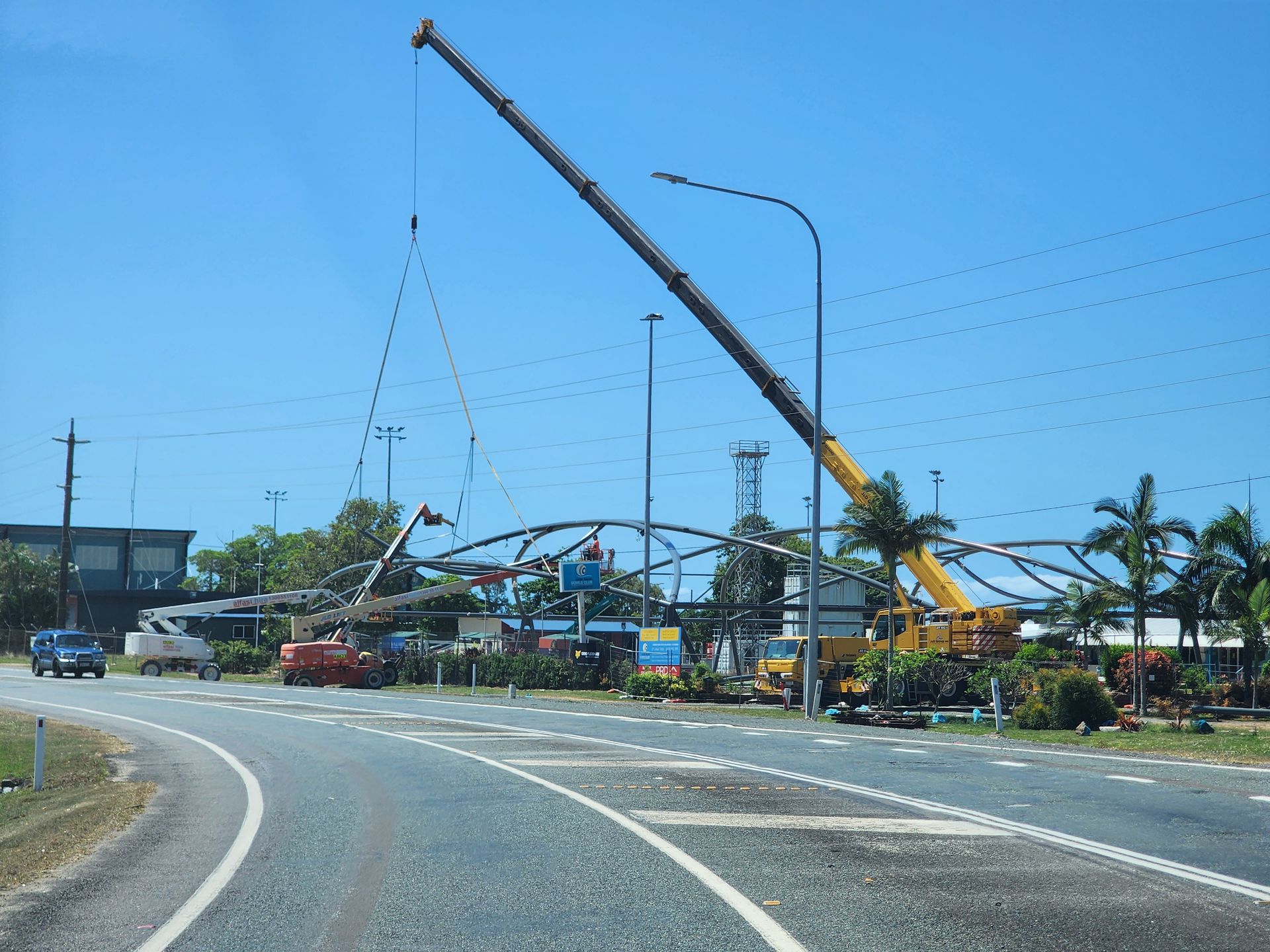 A Yellow Truck With A Crane Attached To It Holding A Tree Stump— J & D Rigging Pty Ltd In Bohle, QLD