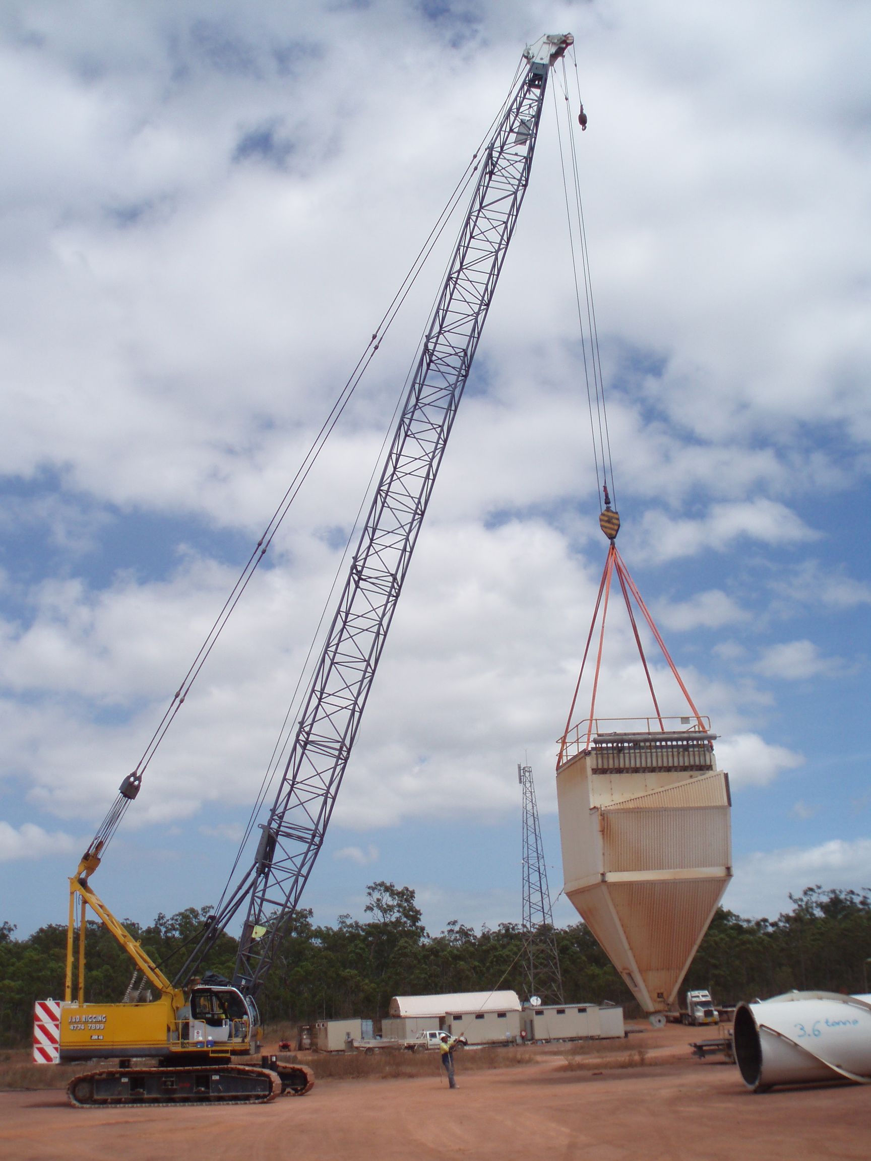 A Large Yellow Crane Is Lifting A Large Object — J & D Rigging Pty Ltd In Bohle, QLD