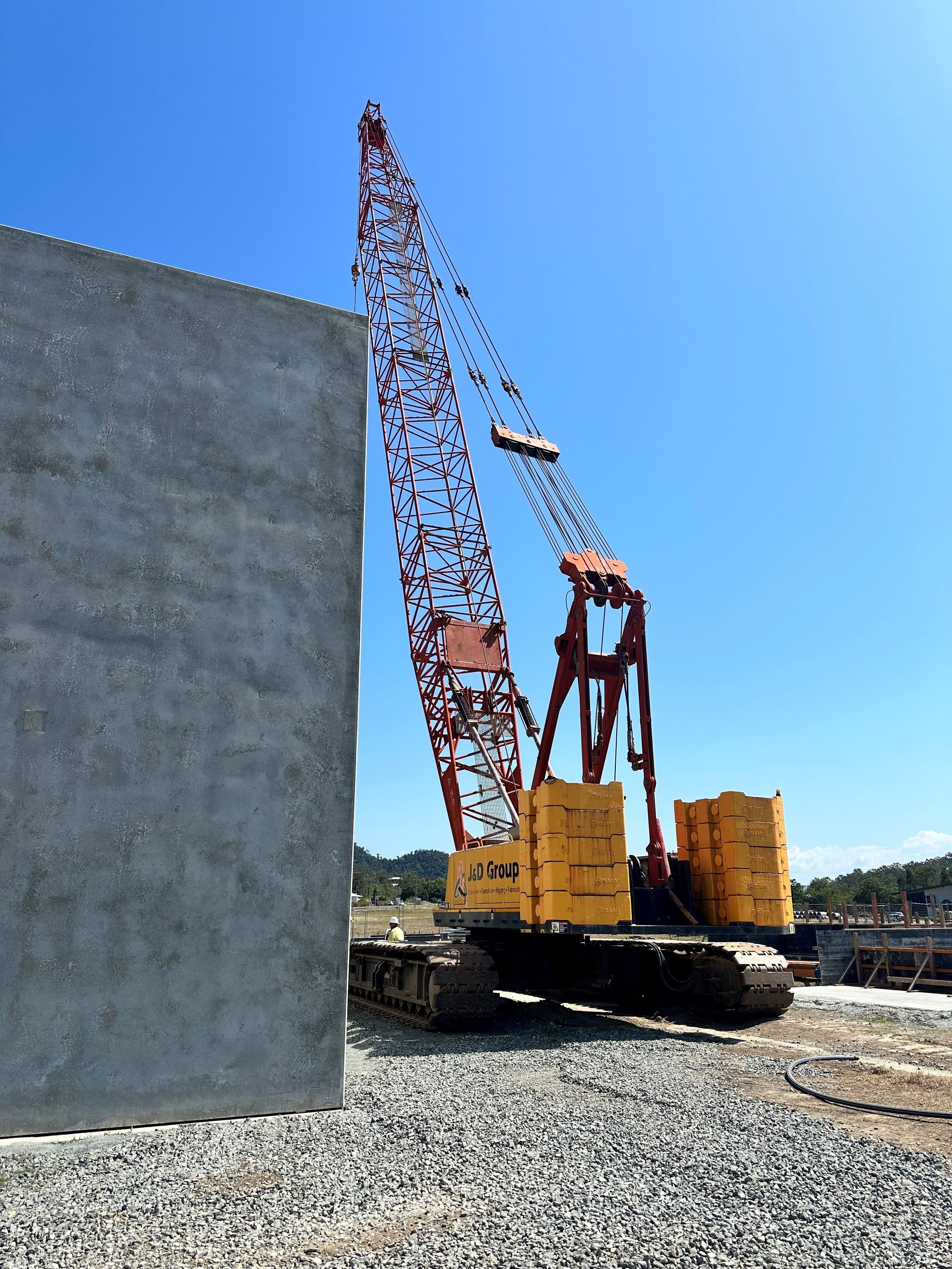 A Large Yellow & Red Crane Is Working On A Construction Site — J & D Rigging Pty Ltd In Bohle, QLD