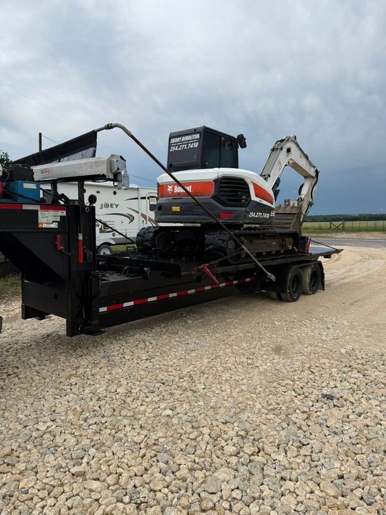 A bobcat excavator is sitting on top of a trailer.