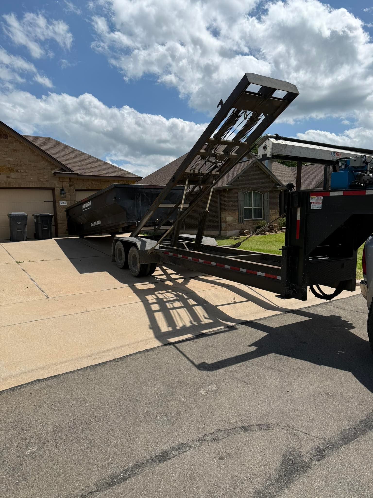 A trailer is parked in a driveway next to a house.