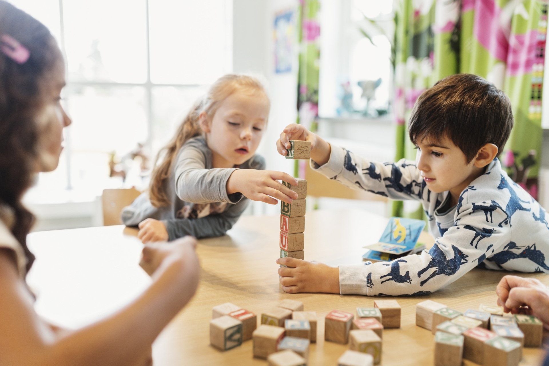 Children stacking alphabet blocks on table — Verona, WI — Once Upon a Time Childcare Center