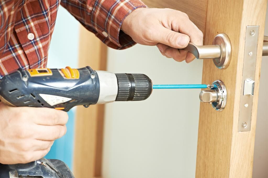 A man is fixing a door with a key.