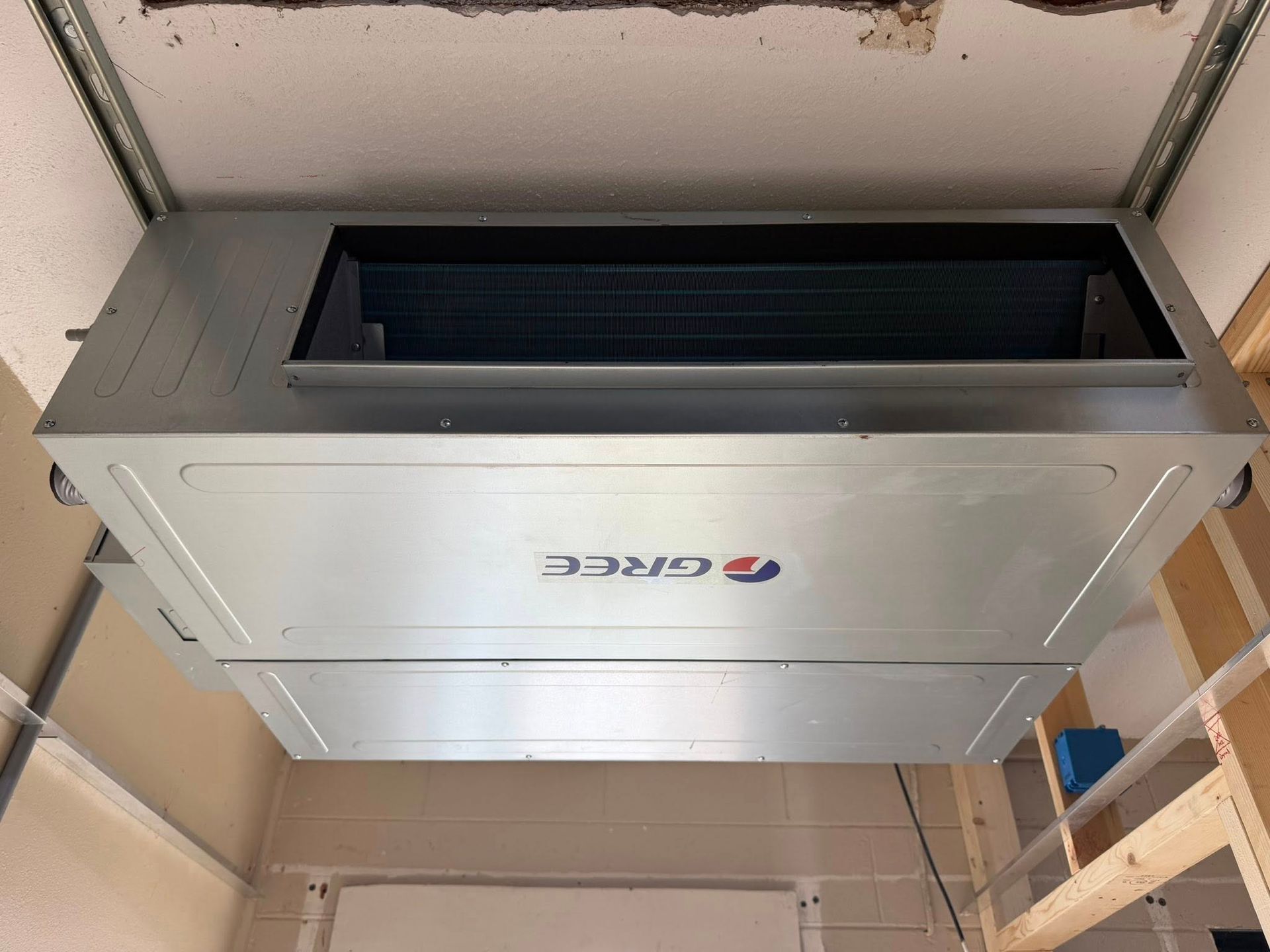 Ceiling-mounted Daikin HVAC unit in a utility room, viewed from below.