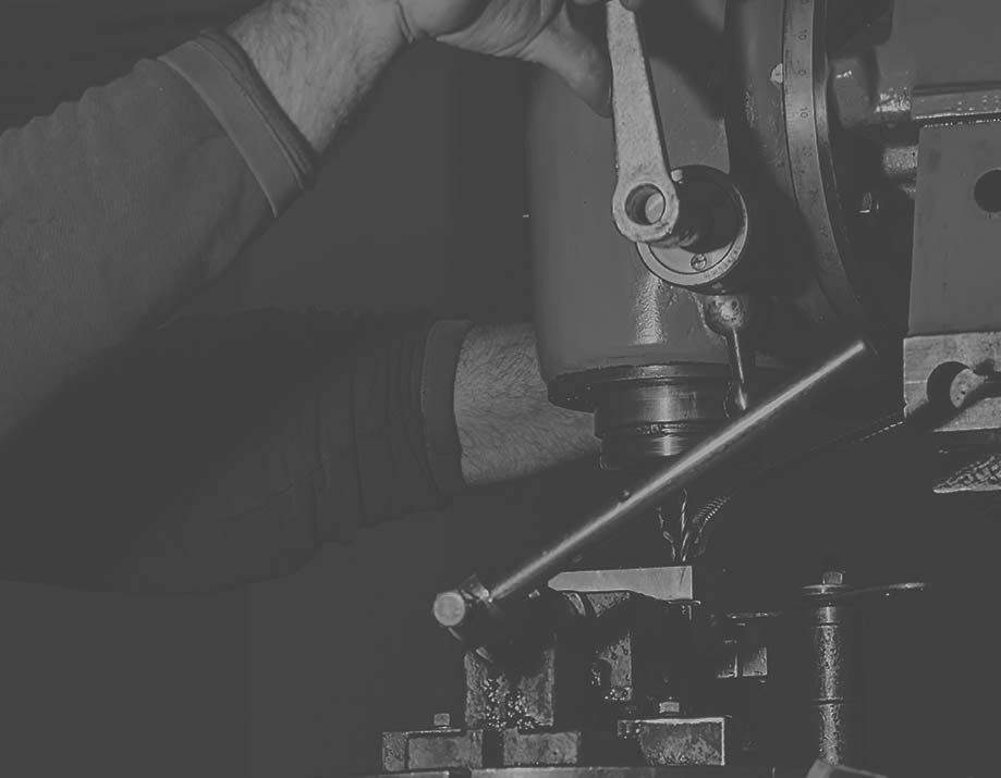 A man is working on a machine in a black and white photo.