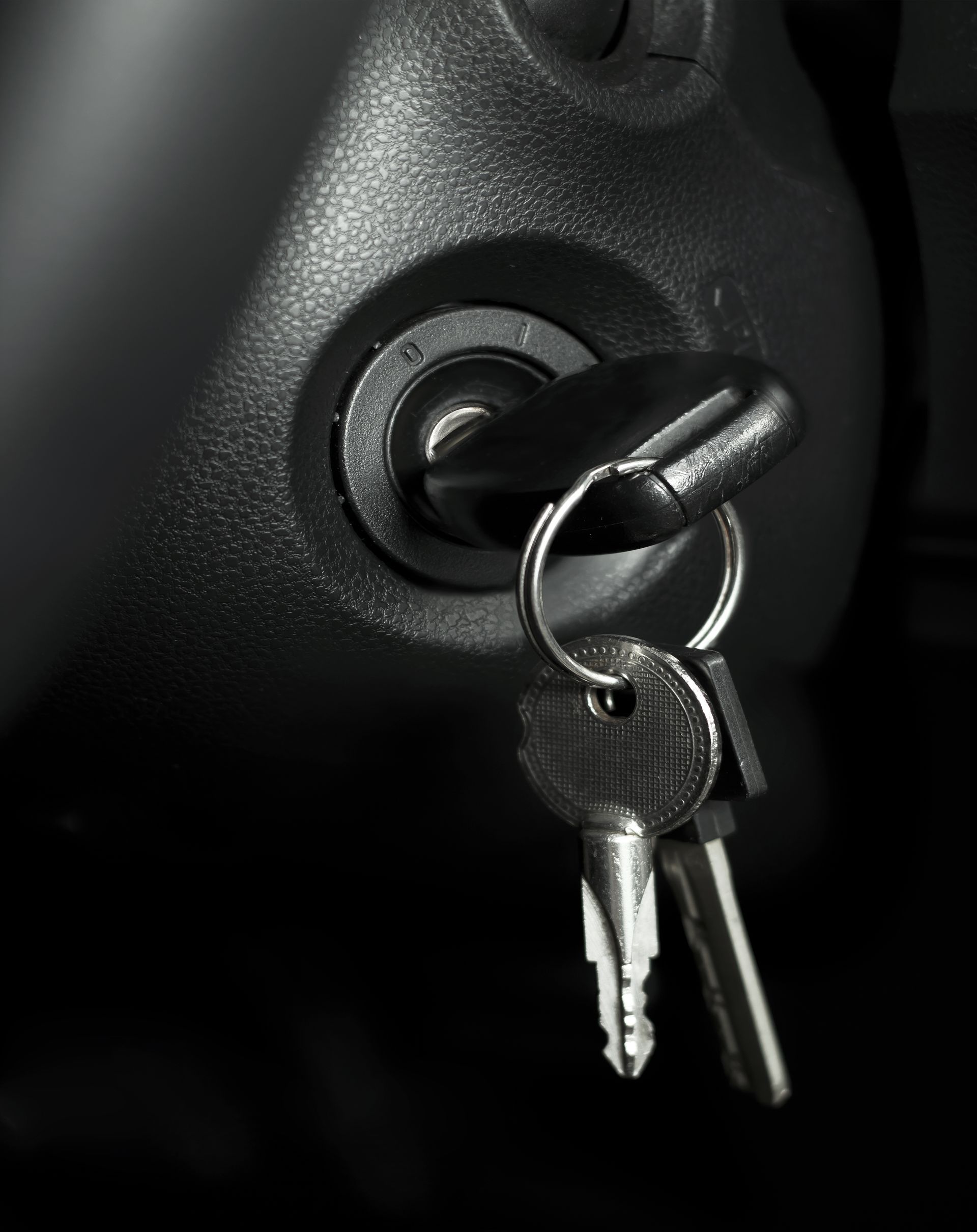 A black and white photo of a car key in the ignition