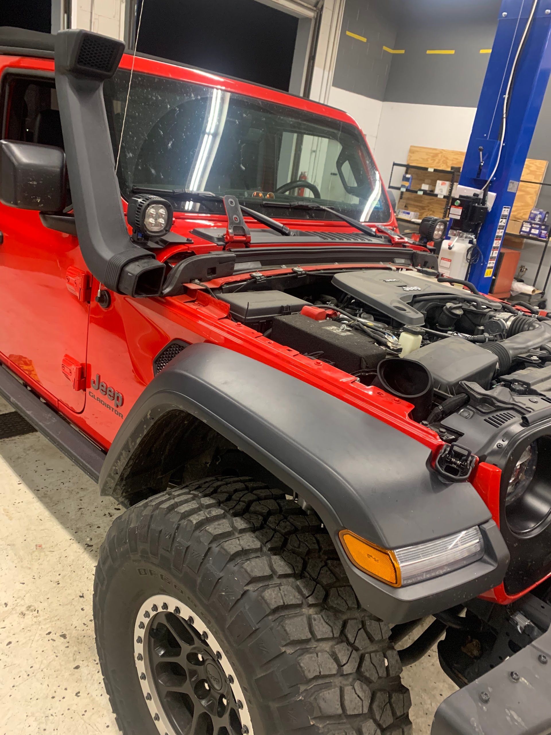 Red Jeep Wrangler with snorkel, hood open, in a garage | JP Automotive, LLC