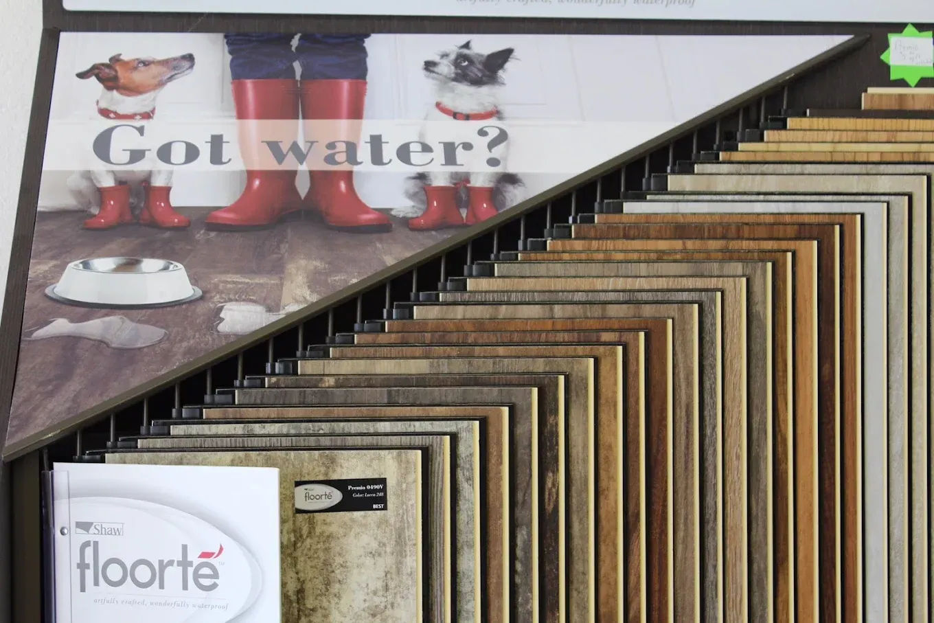 Display of flooring samples with an advertisement showing dogs and a spilled water bowl, promoting waterproof flooring.