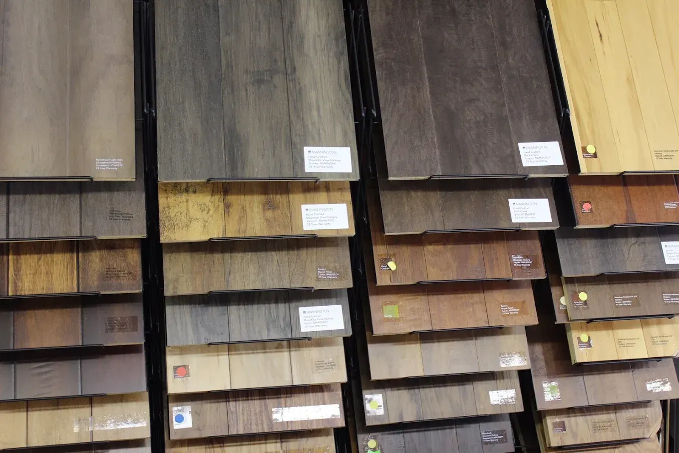 Wooden flooring samples in various shades of brown, arranged on a display rack.