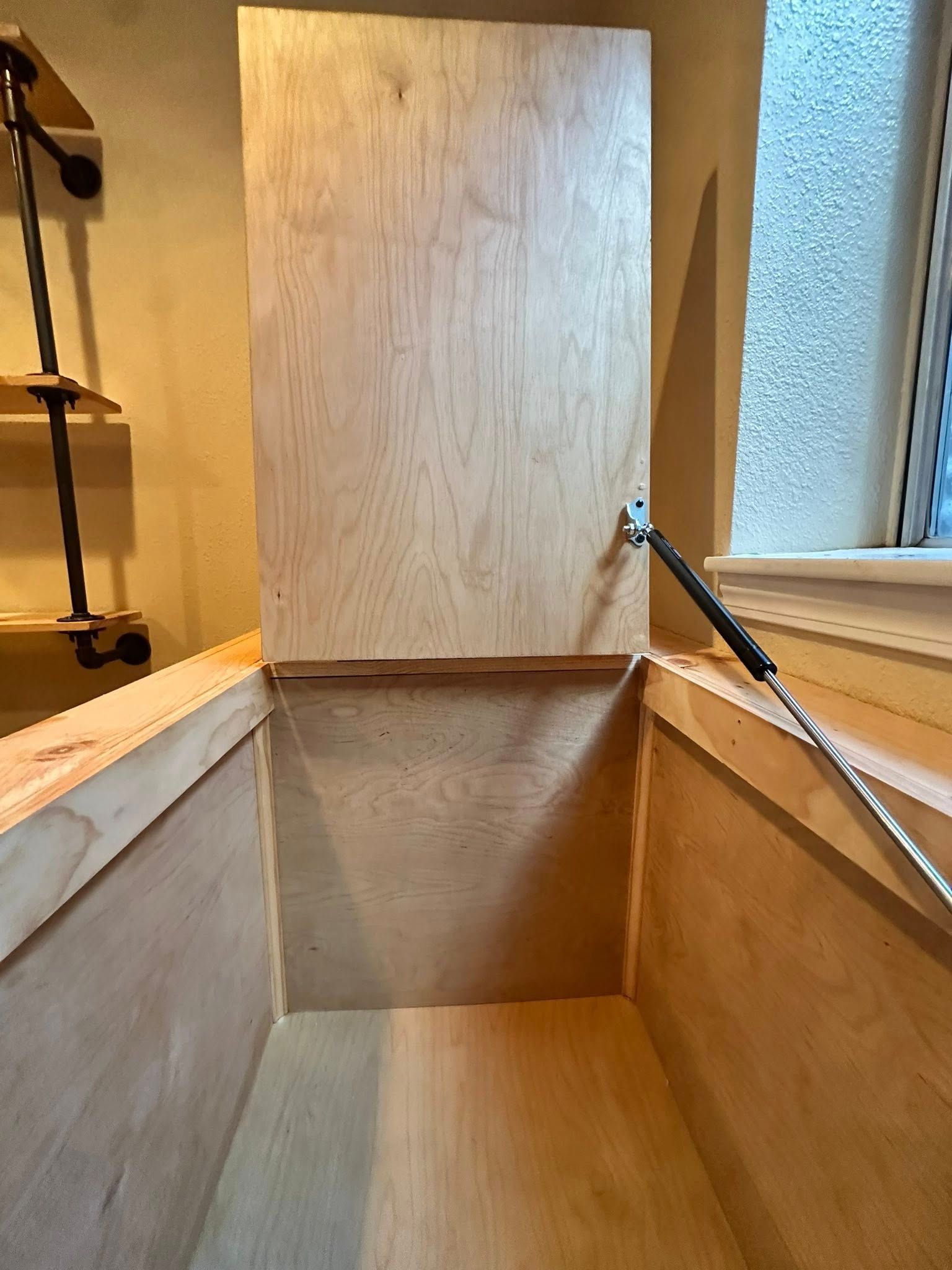 Open wooden storage chest with hinged lid, interior view.