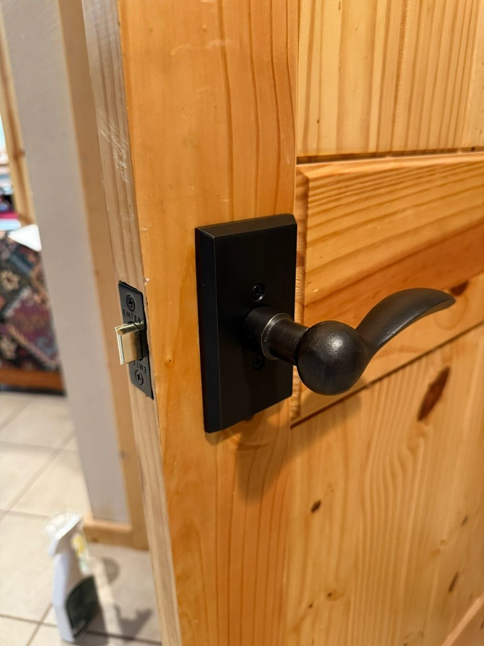 Bathroom with rustic wood vanity, black bowl sink, tiled shower, and toilet.