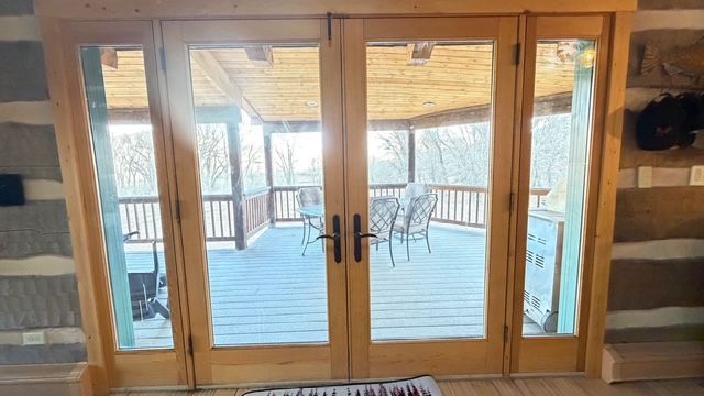 Small bathroom with a white tub, toilet, and a speckled gray and black tiled shower area.
