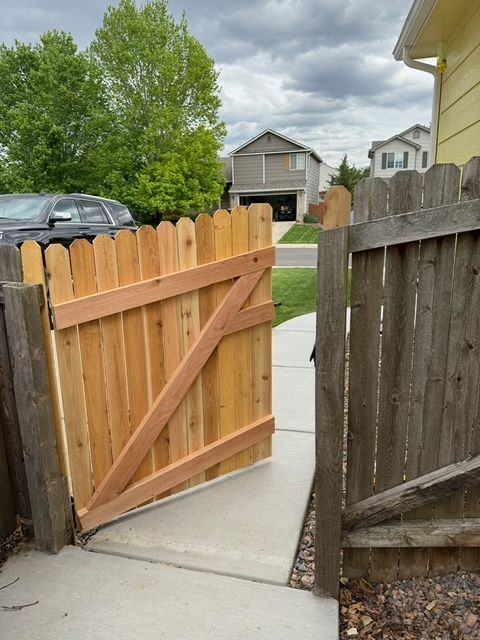 Small bathroom with green vanity, white toilet, and light wood-look flooring.