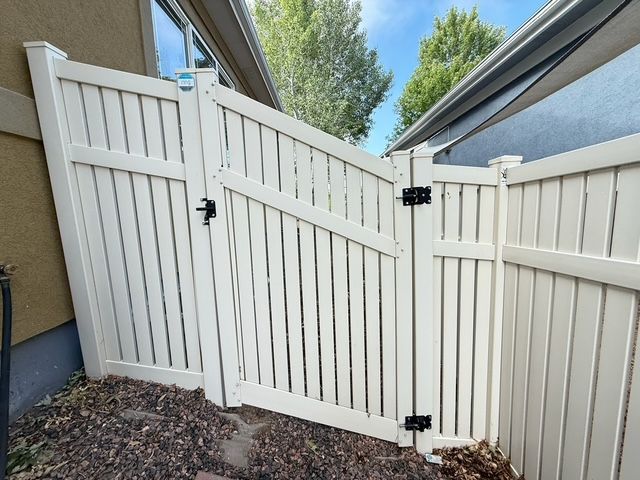 Small bathroom with a white tub, toilet, and a speckled gray and black tiled shower area.