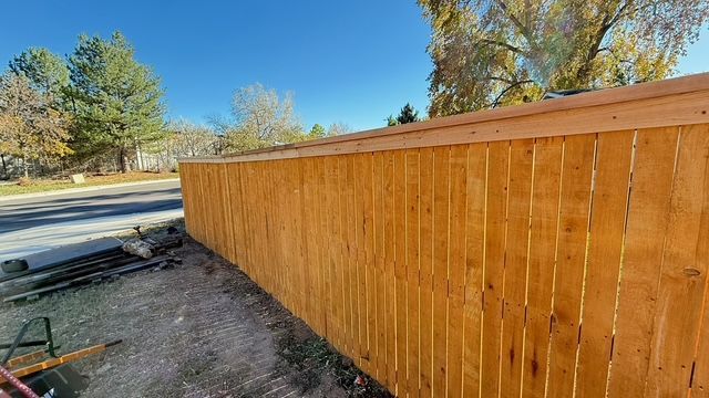 Bathroom with rustic wood vanity, black bowl sink, tiled shower, and toilet.