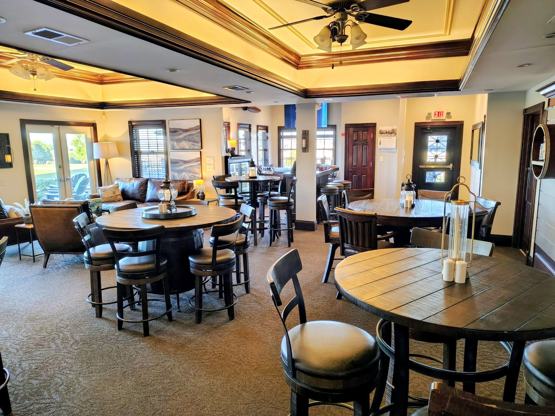 Interior of a restaurant with multiple tables and seating, warm lighting, and decorative ceiling details.