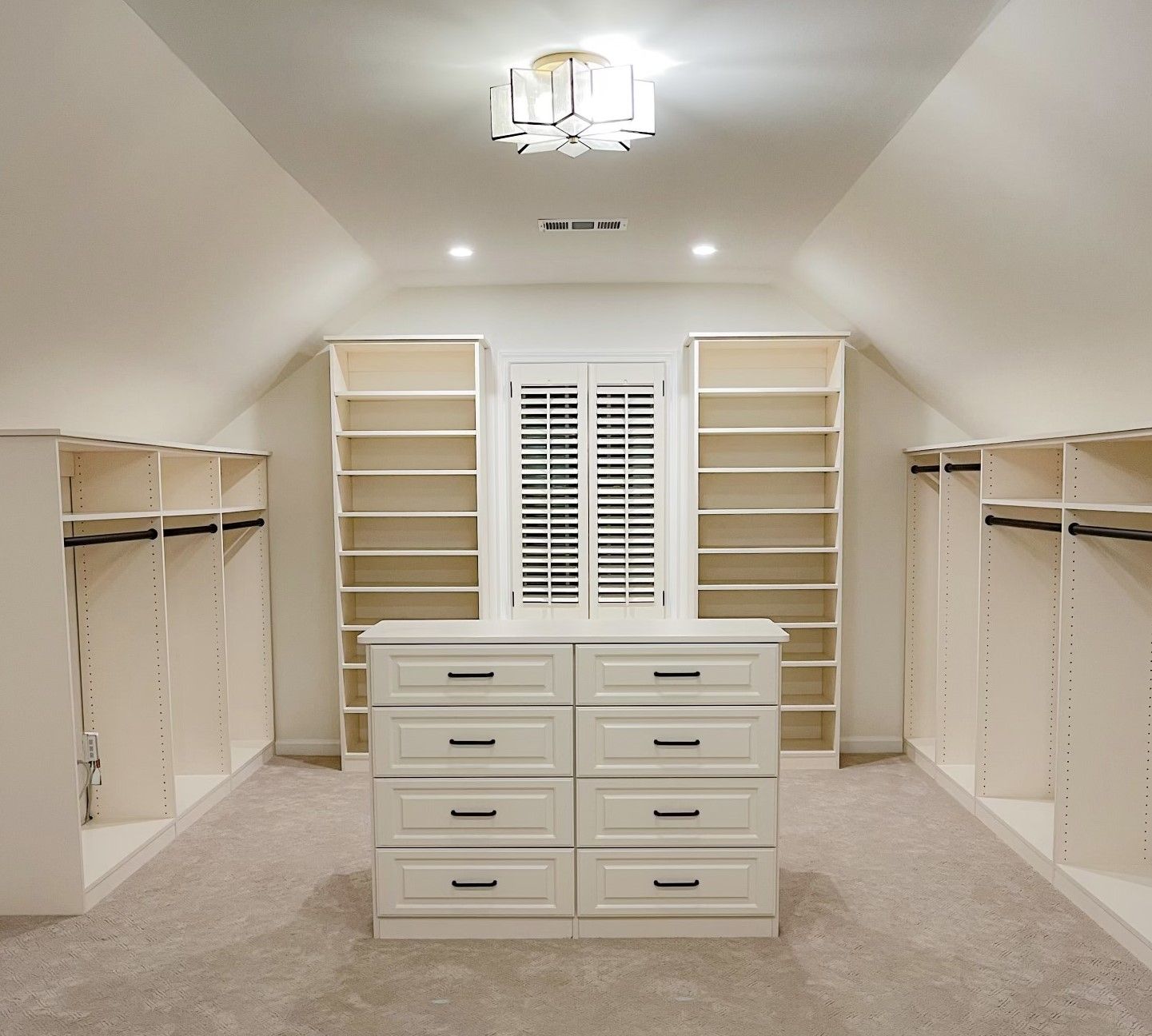 A walk in closet with lots of shelves and drawers