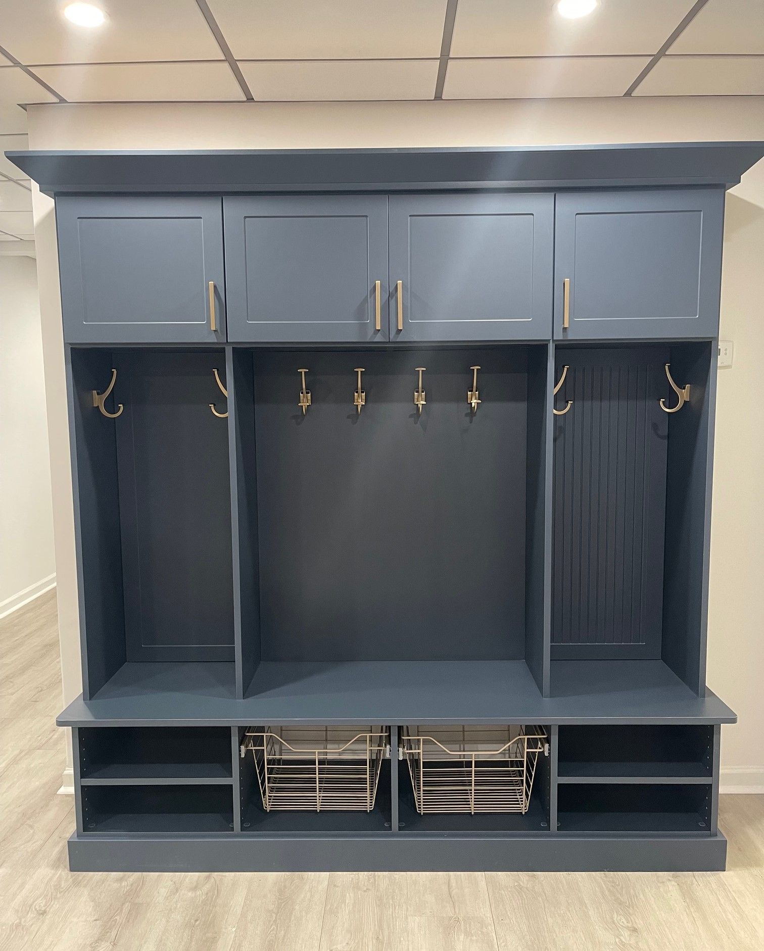 A large gray cabinet with hooks and shelves in a room.
