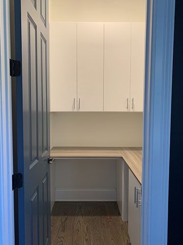 A room with a desk and cabinets in it.