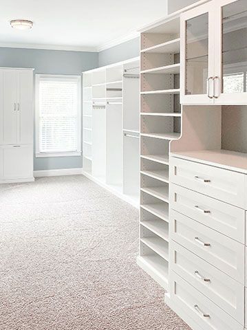 A large walk in closet with lots of shelves and drawers.