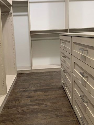 A walk in closet with lots of drawers and shelves.