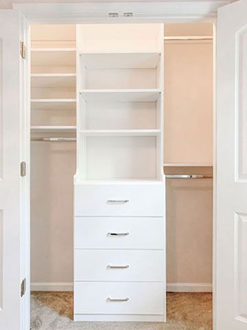 A walk in closet with shelves and drawers in a bedroom.