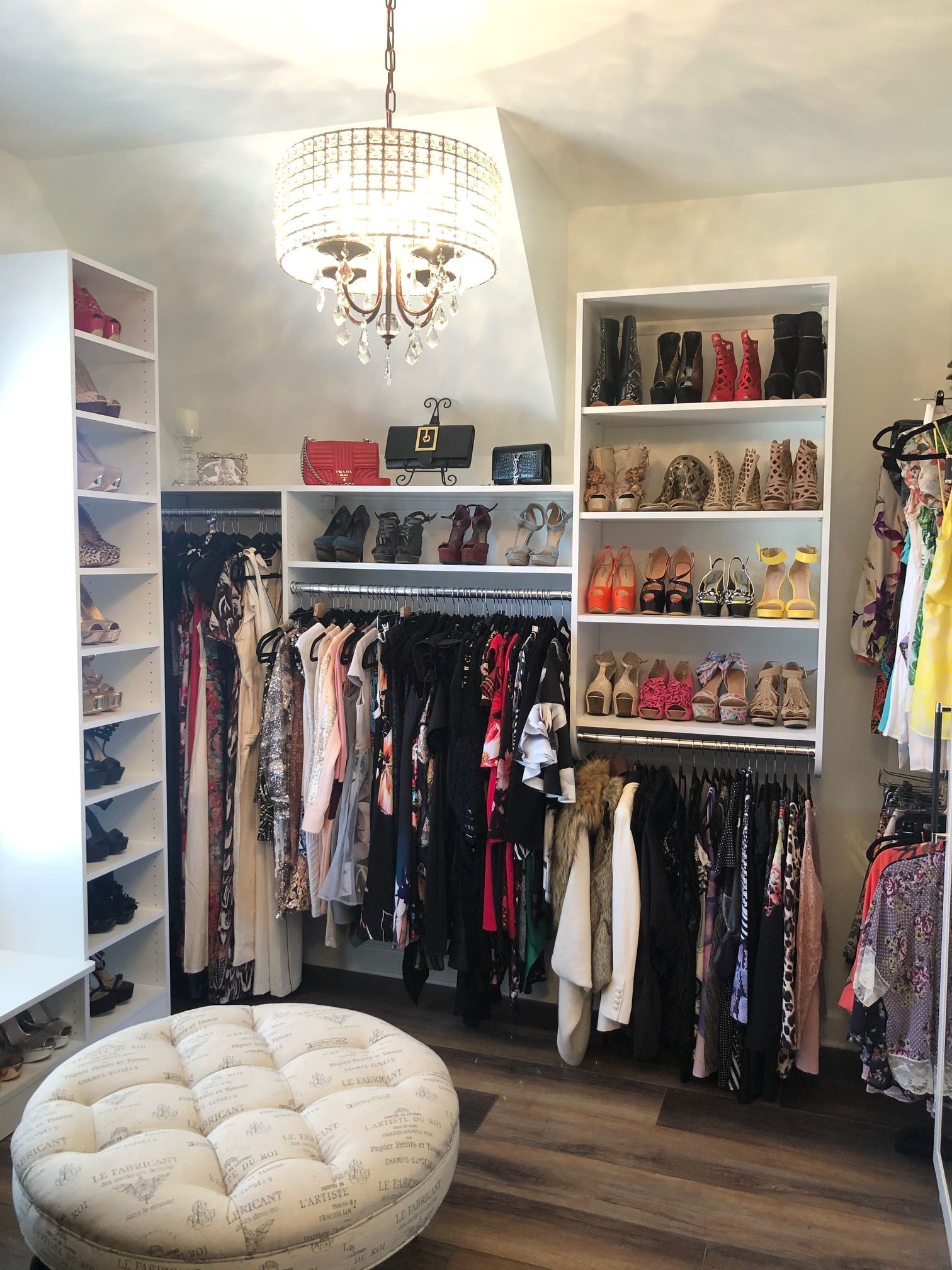 A large walk in closet filled with lots of clothes and shoes.