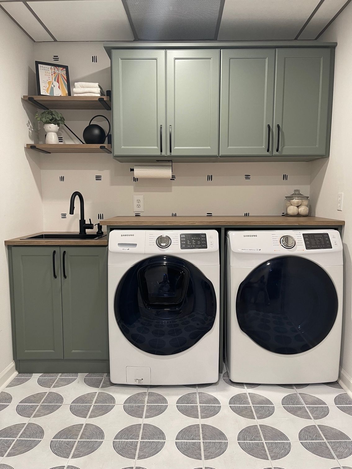 A laundry room with two washing machines and a sink.
