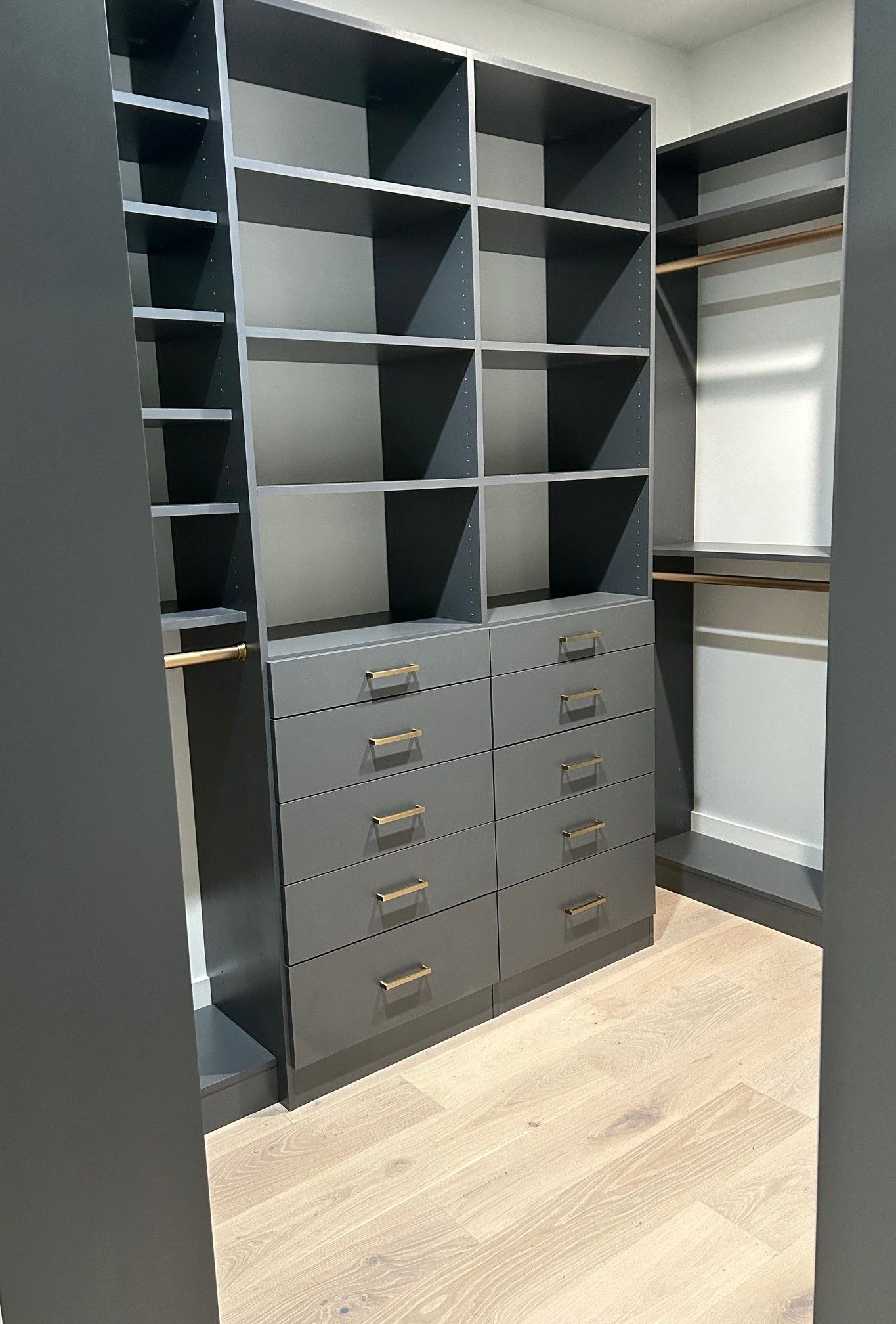 A walk in closet with lots of shelves and drawers.