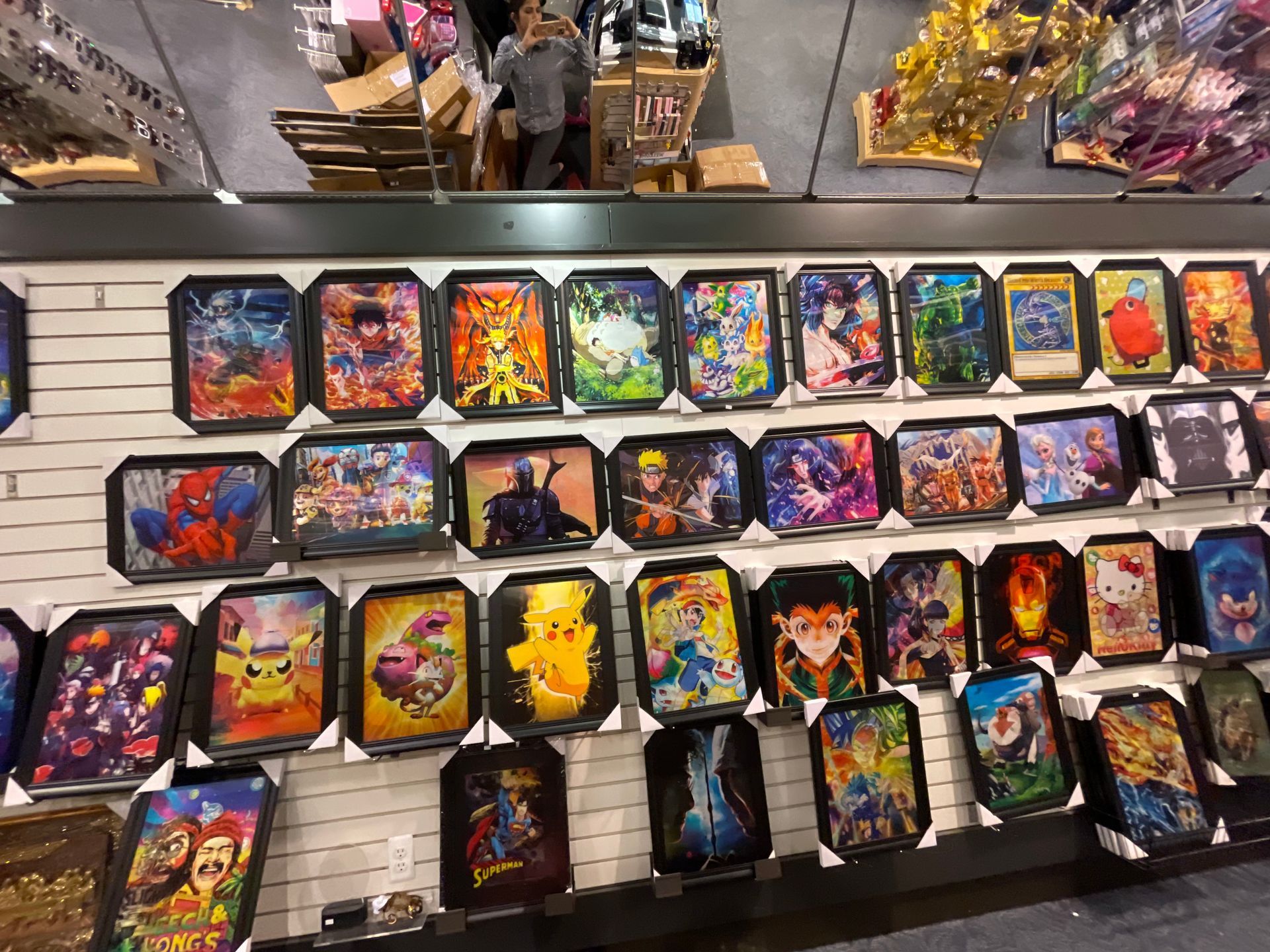 A wall filled with lots of framed pictures of cartoon characters.