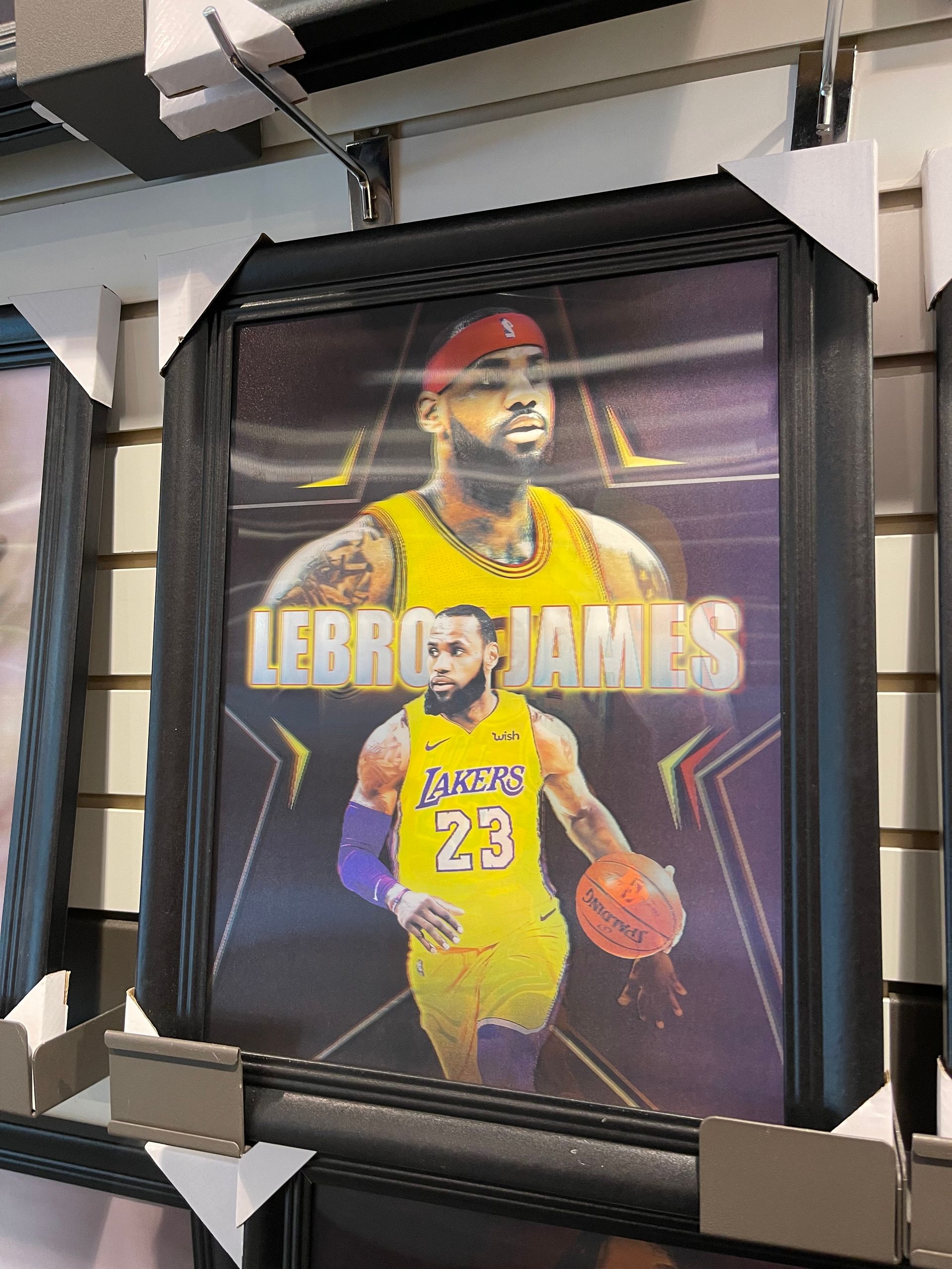 A framed picture of lebron james is hanging on a wall