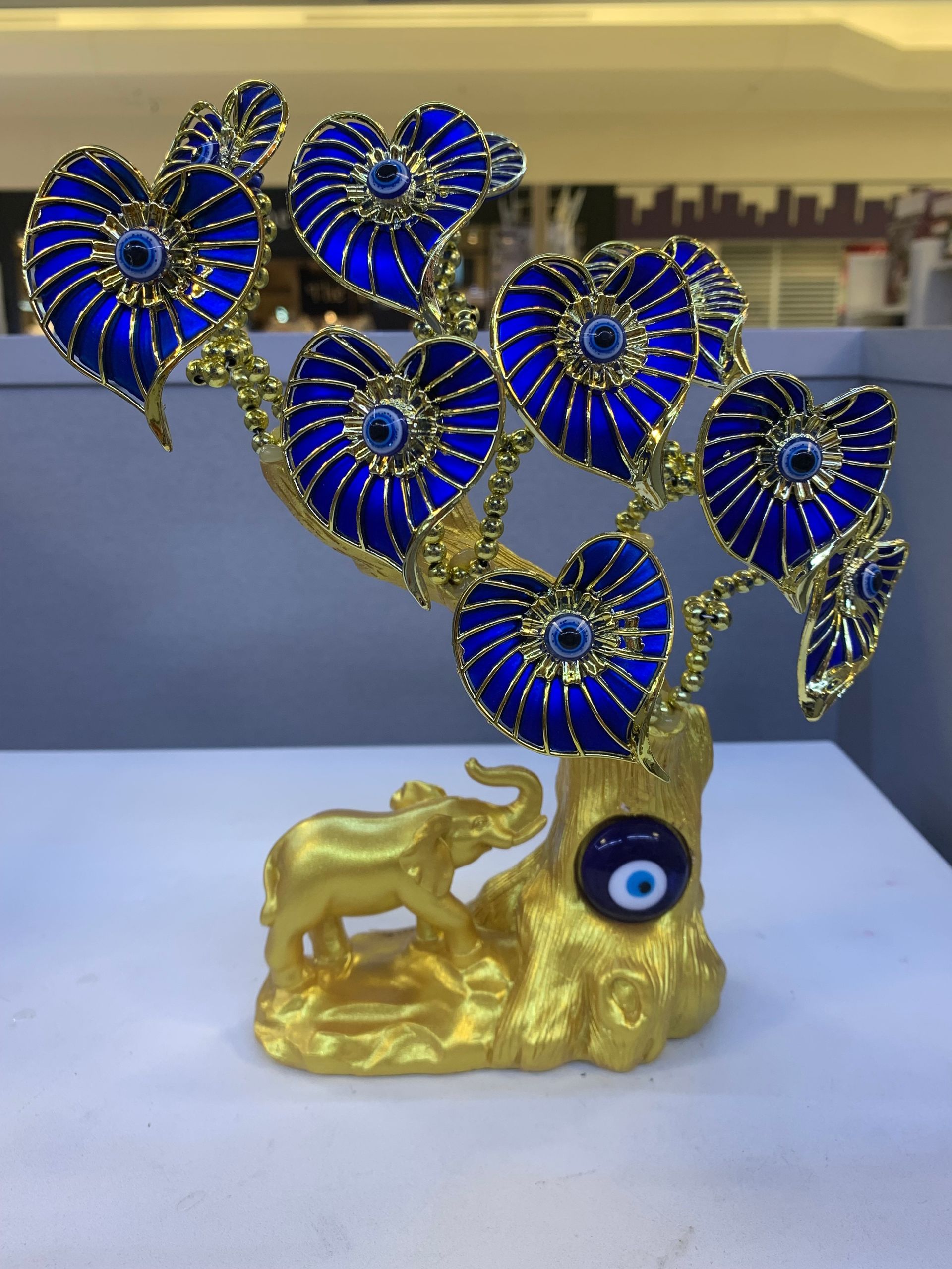 A statue of an elephant and a tree with blue flowers