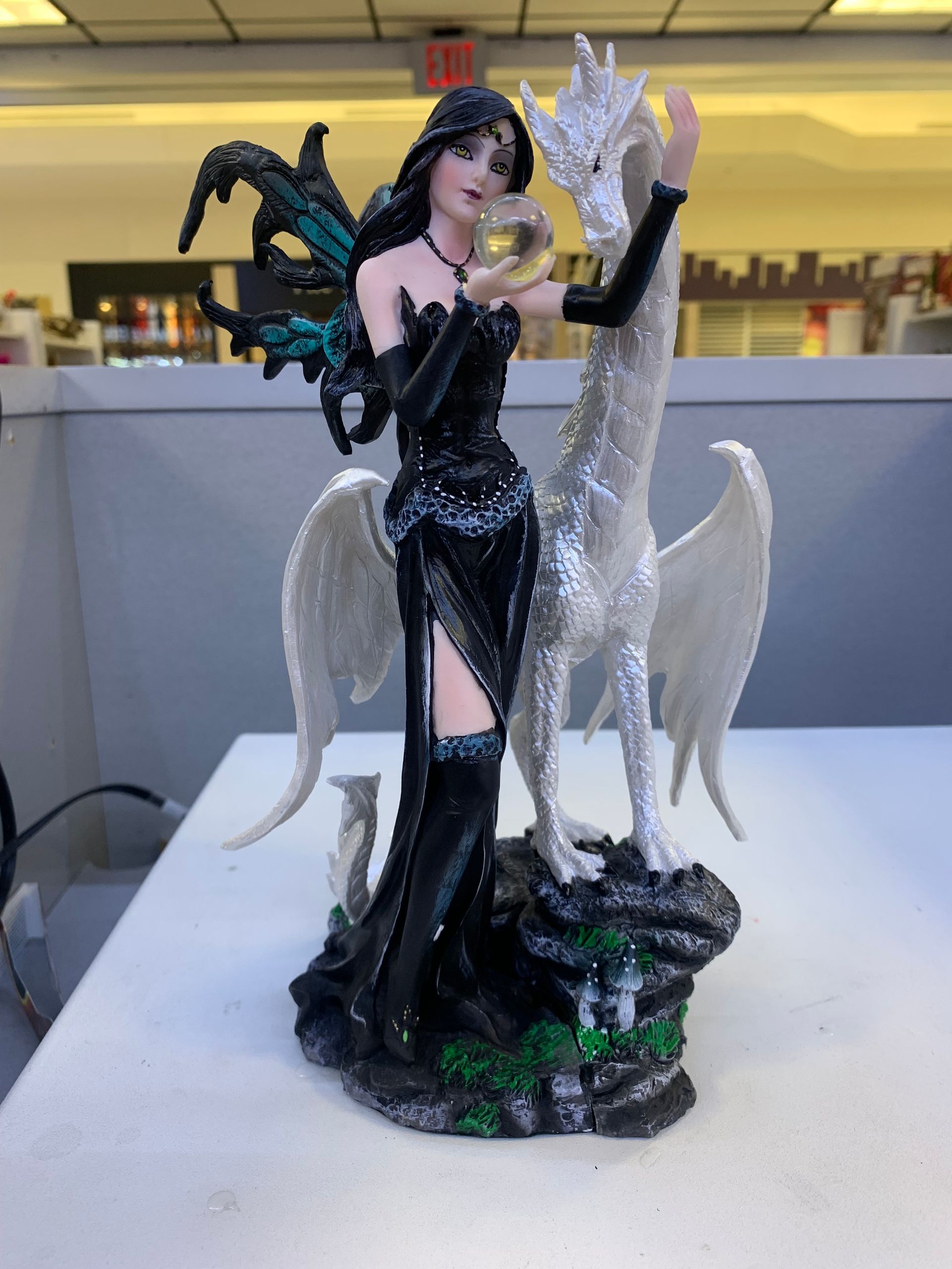 A statue of a woman standing next to a white dragon