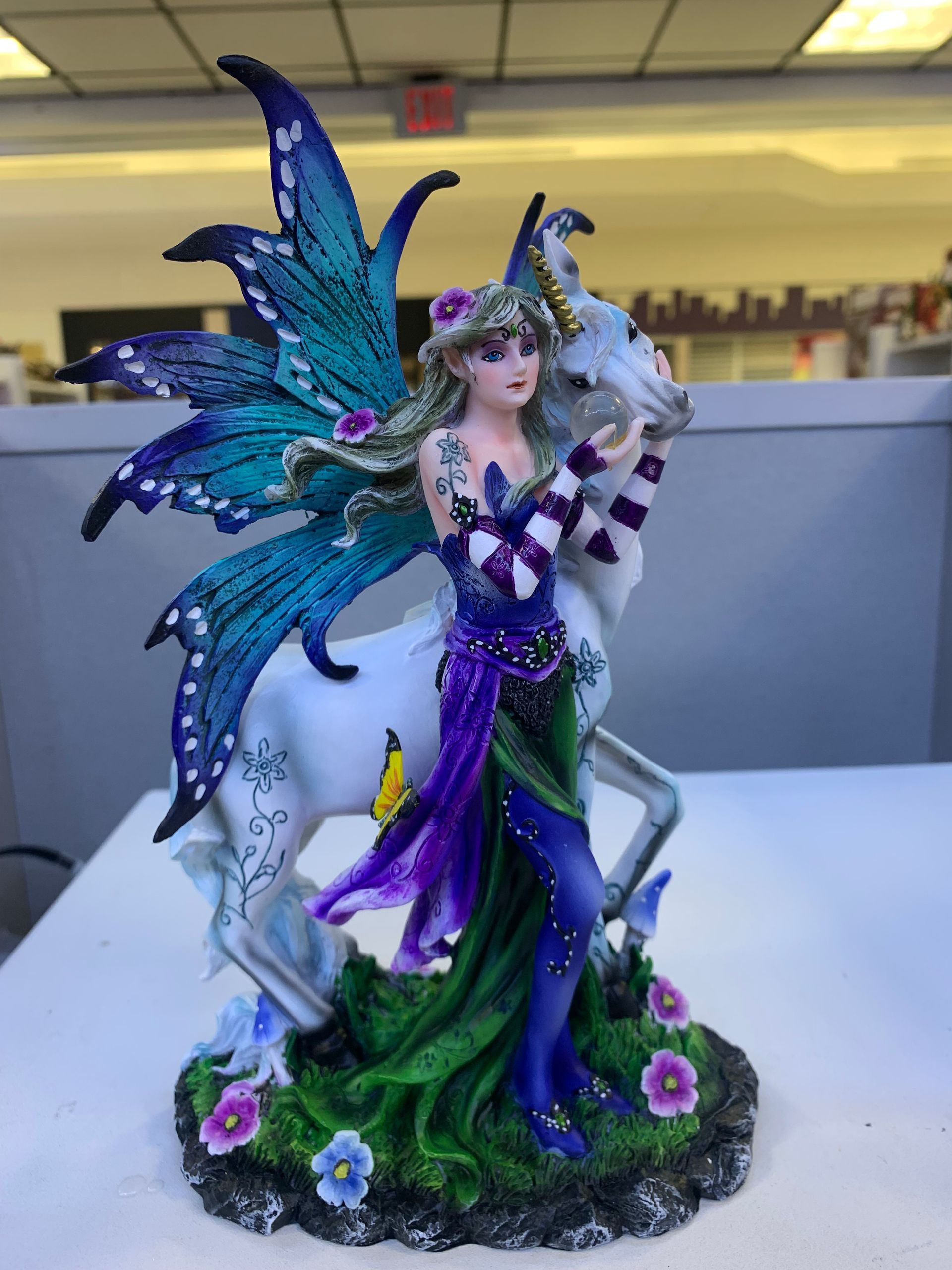 A statue of a fairy standing next to a unicorn