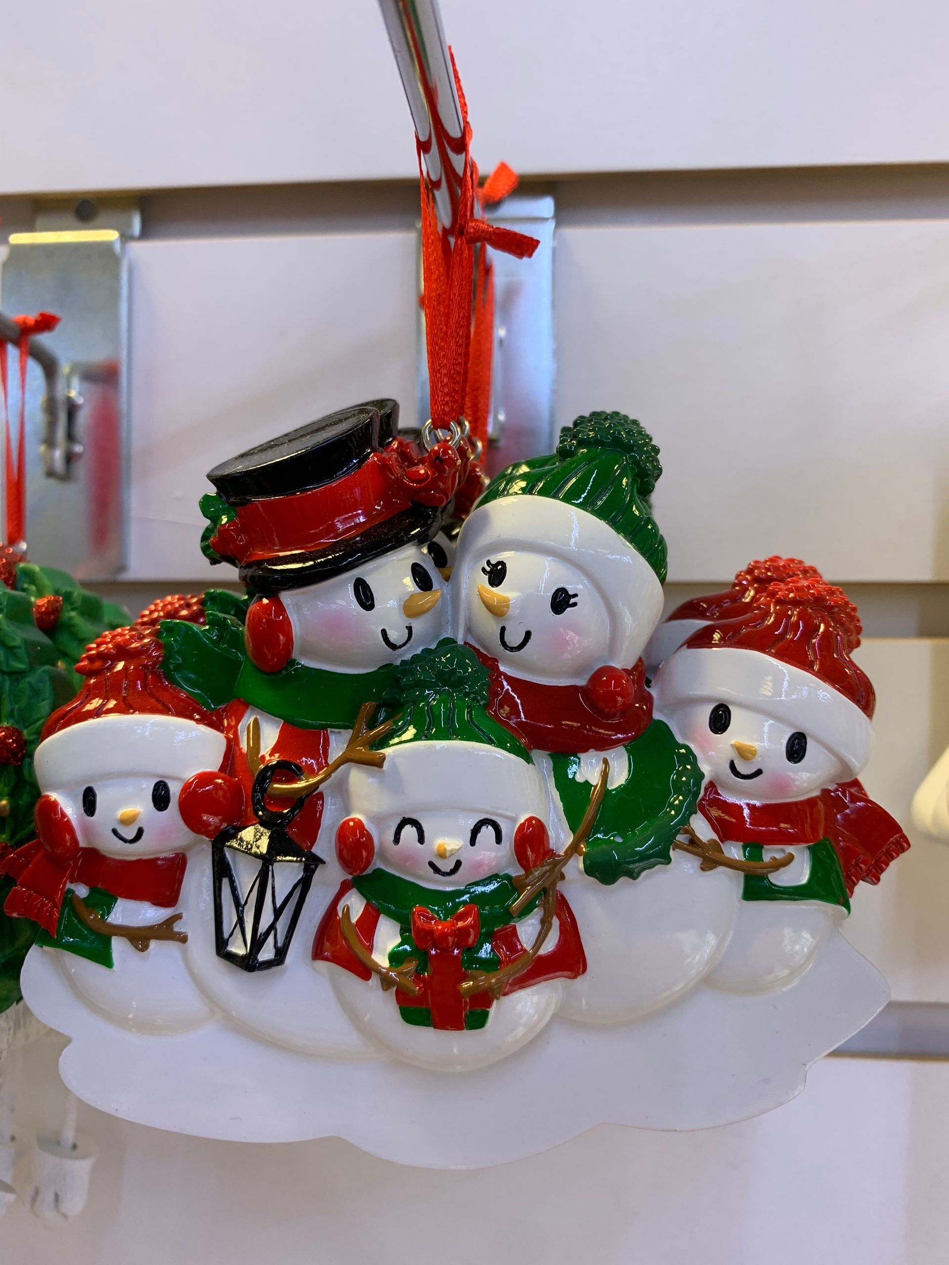 A christmas ornament with four snowmen on it