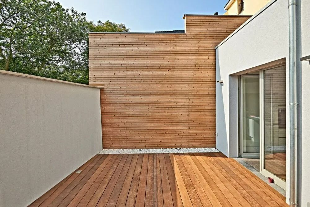 Modern Wooden Deck Patio Beside a White Wall and Glass Doors — Greg Pollard Building in Banora Point, NSW