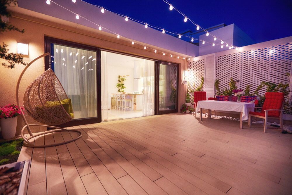 Modern Rooftop Patio at Night With String Lights, Sliding Glass Doors, and Seating — Greg Pollard Building in Kingscliff, NSW