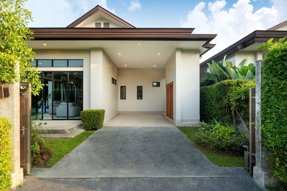 Modern House Entrance With a Driveway, White Facade, and Green Landscaping — Greg Pollard Building in Terranora, NSW