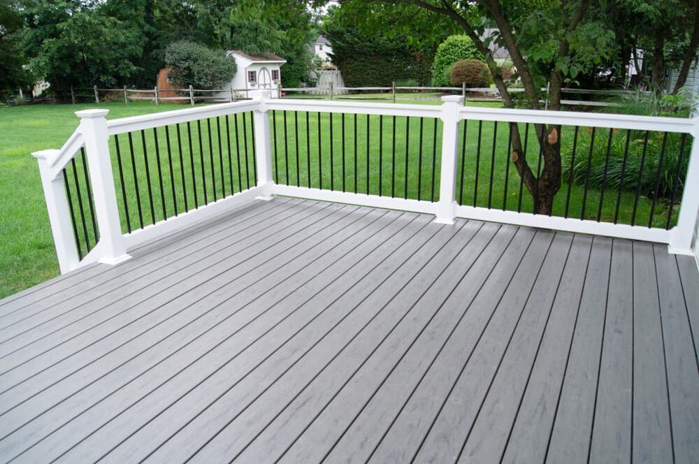 White-railed Gray Deck Overlooking a Green Backyard With Trees and Lawn — Greg Pollard Building in Pottsville, NSW