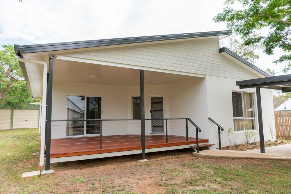 Covered Porch With Wooden Deck, Black Railings, and White Siding on a Small House — Greg Pollard Building in Bogangar, NSW