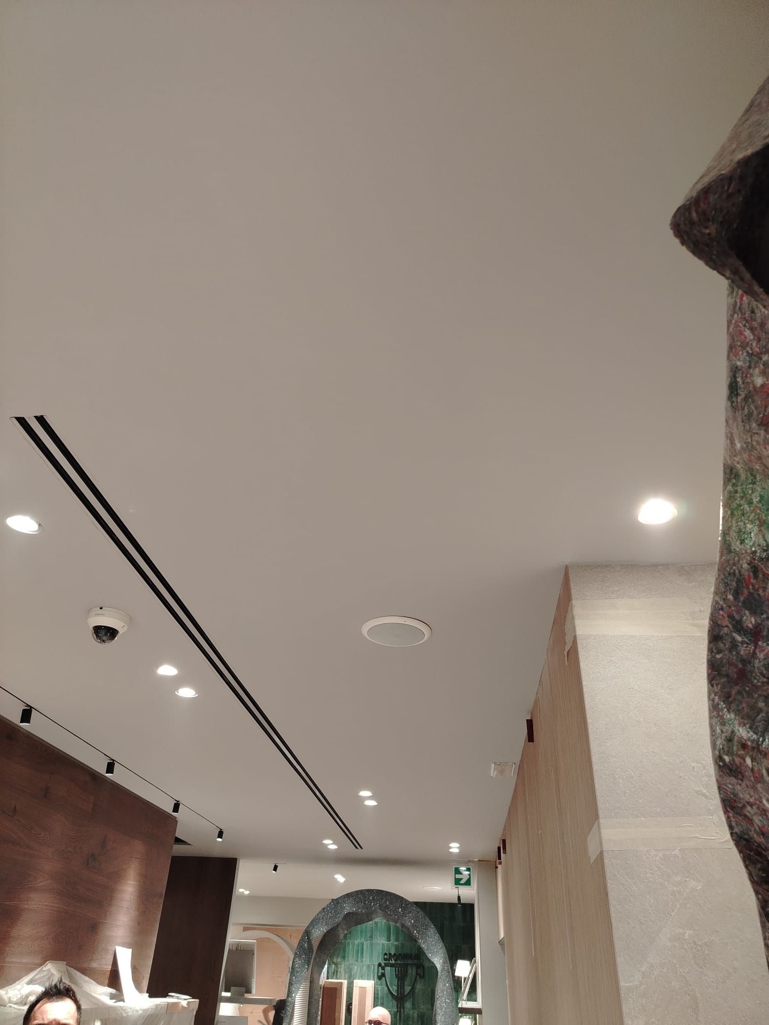 Soffitto con luci da incasso e bocchette di ventilazione; interno di un negozio.