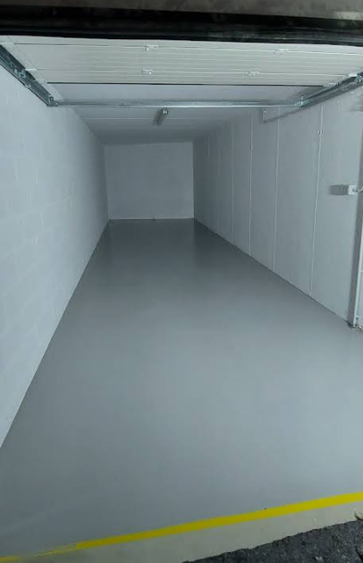 Mobiletto vuoto con pavimento grigio, pareti bianche e controsoffitto incassato.