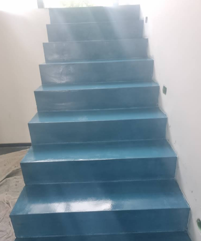 Scala dipinta di blu contro un muro bianco.