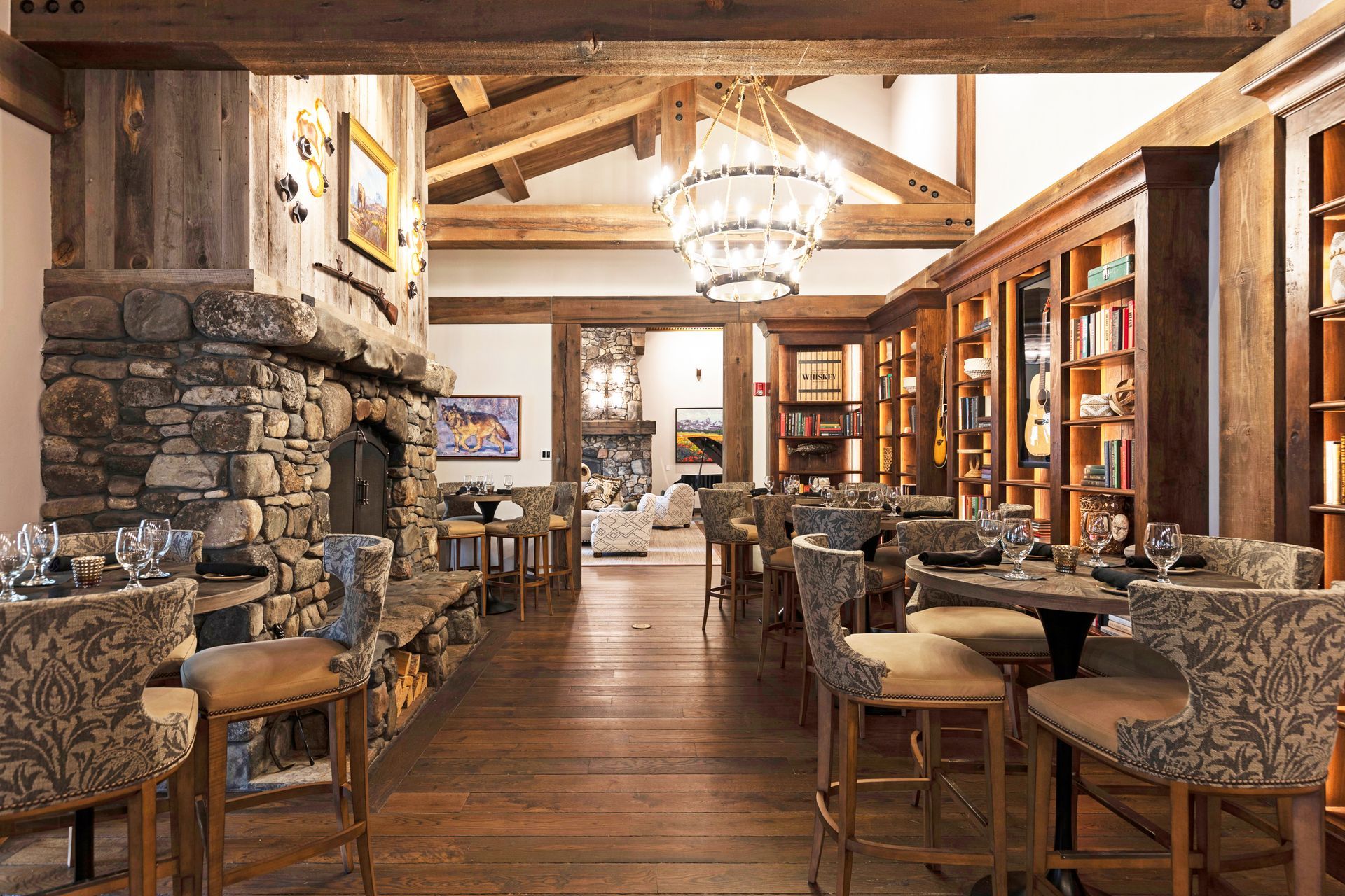 A large dining room with tables and chairs and a fireplace.