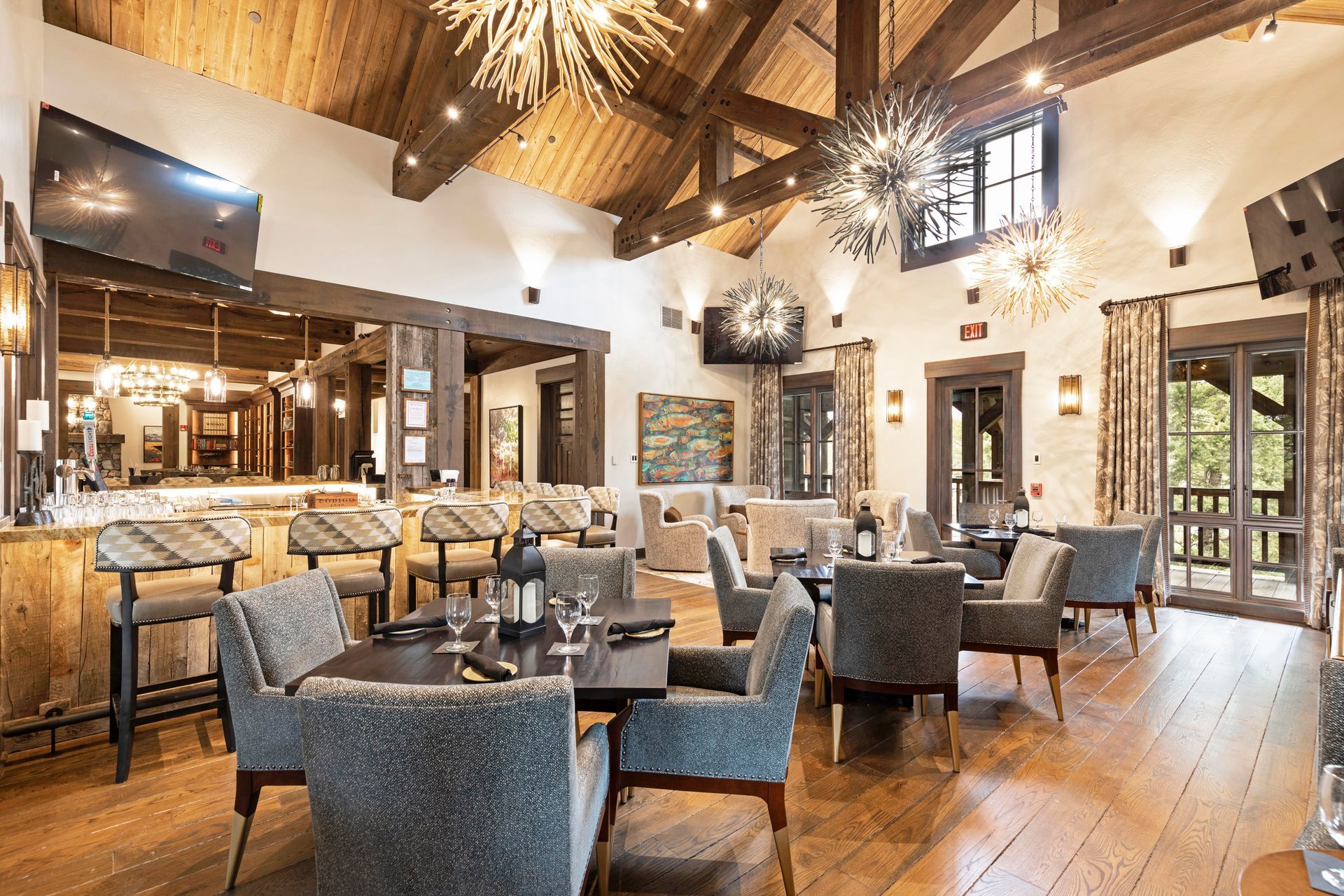 A large dining room with tables and chairs and a bar.