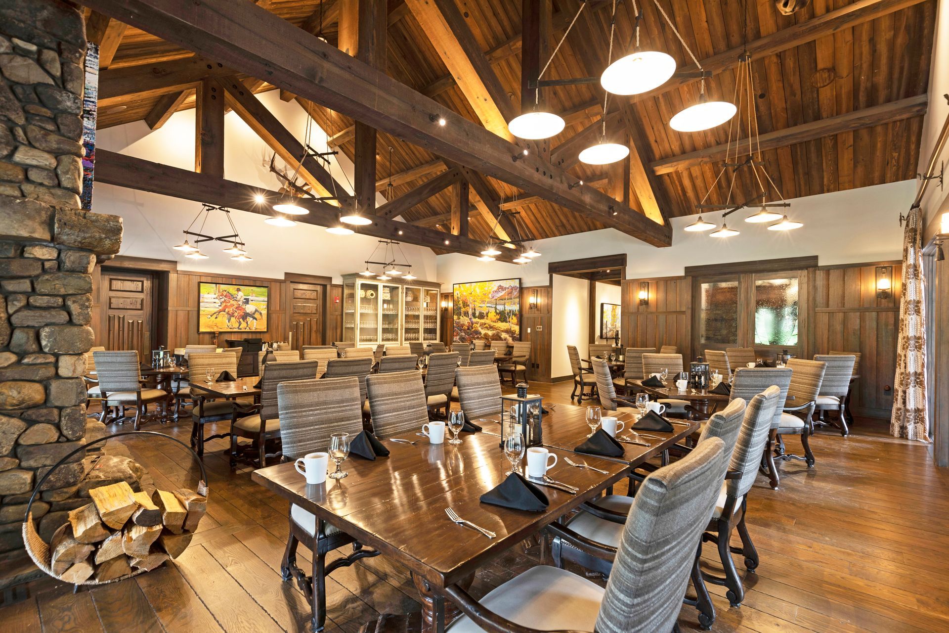 A large dining room with tables and chairs and a fireplace