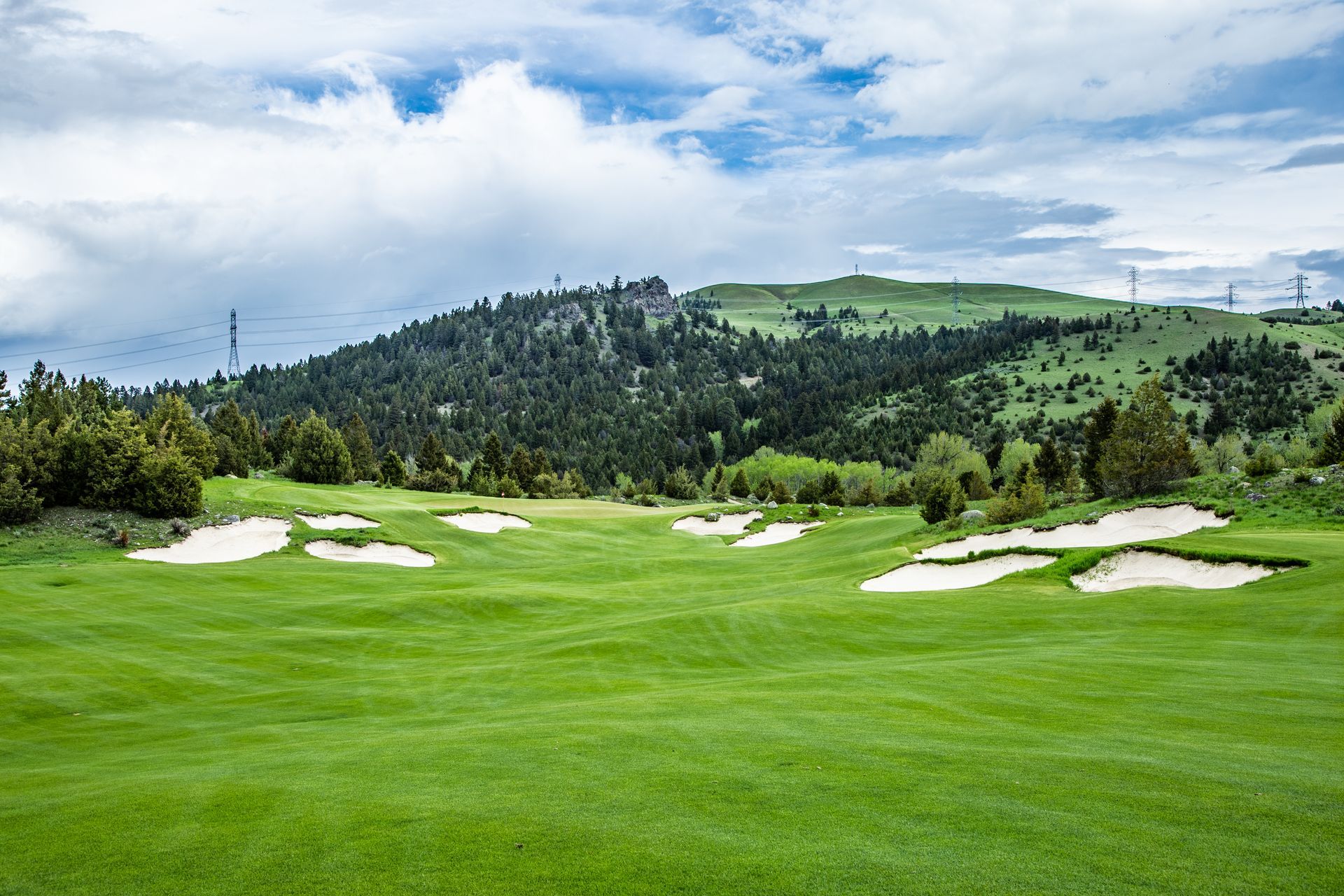 A golf course with a mountain in the background and a lot of bunkers.