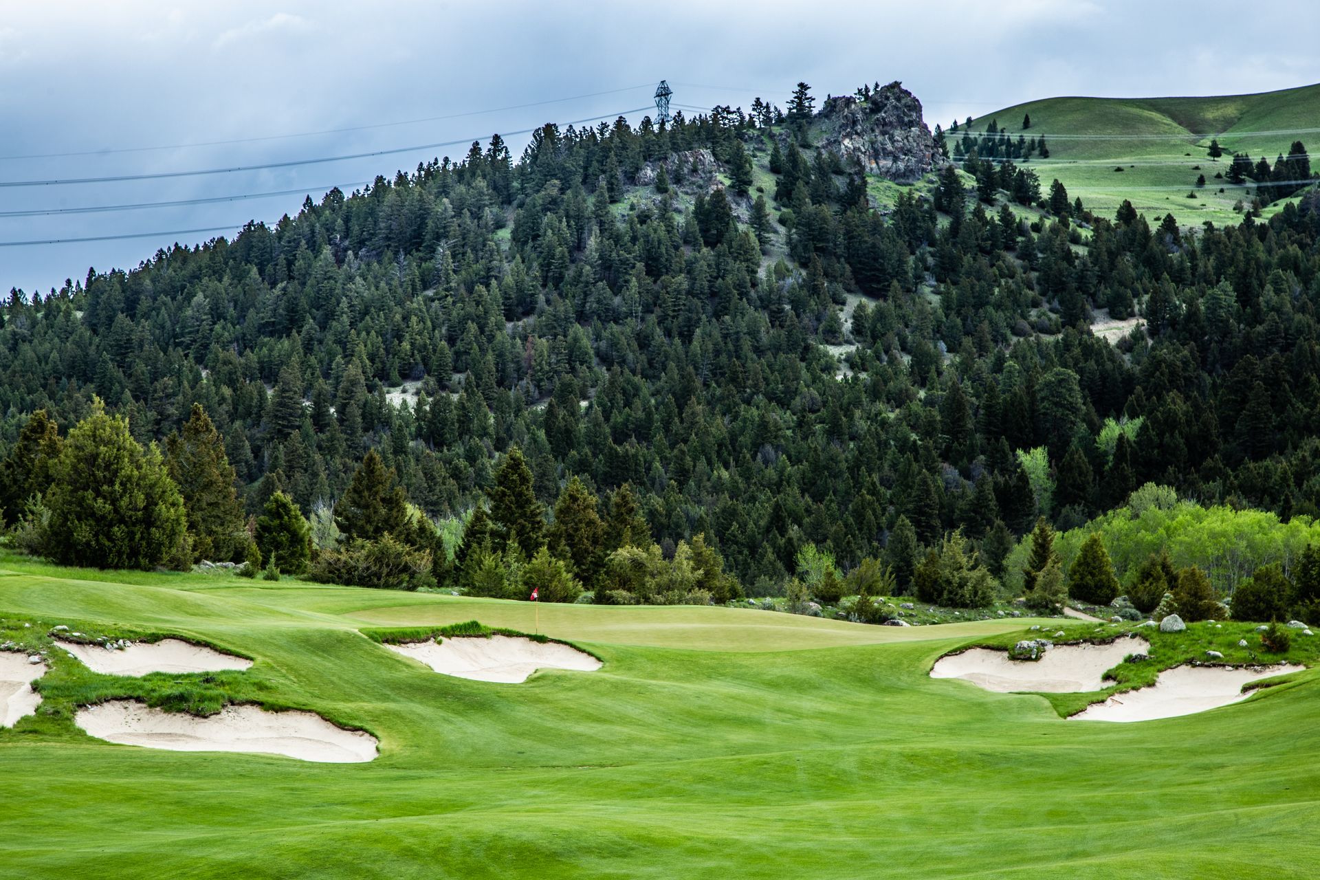 A golf course with a mountain in the background and a lush green field.