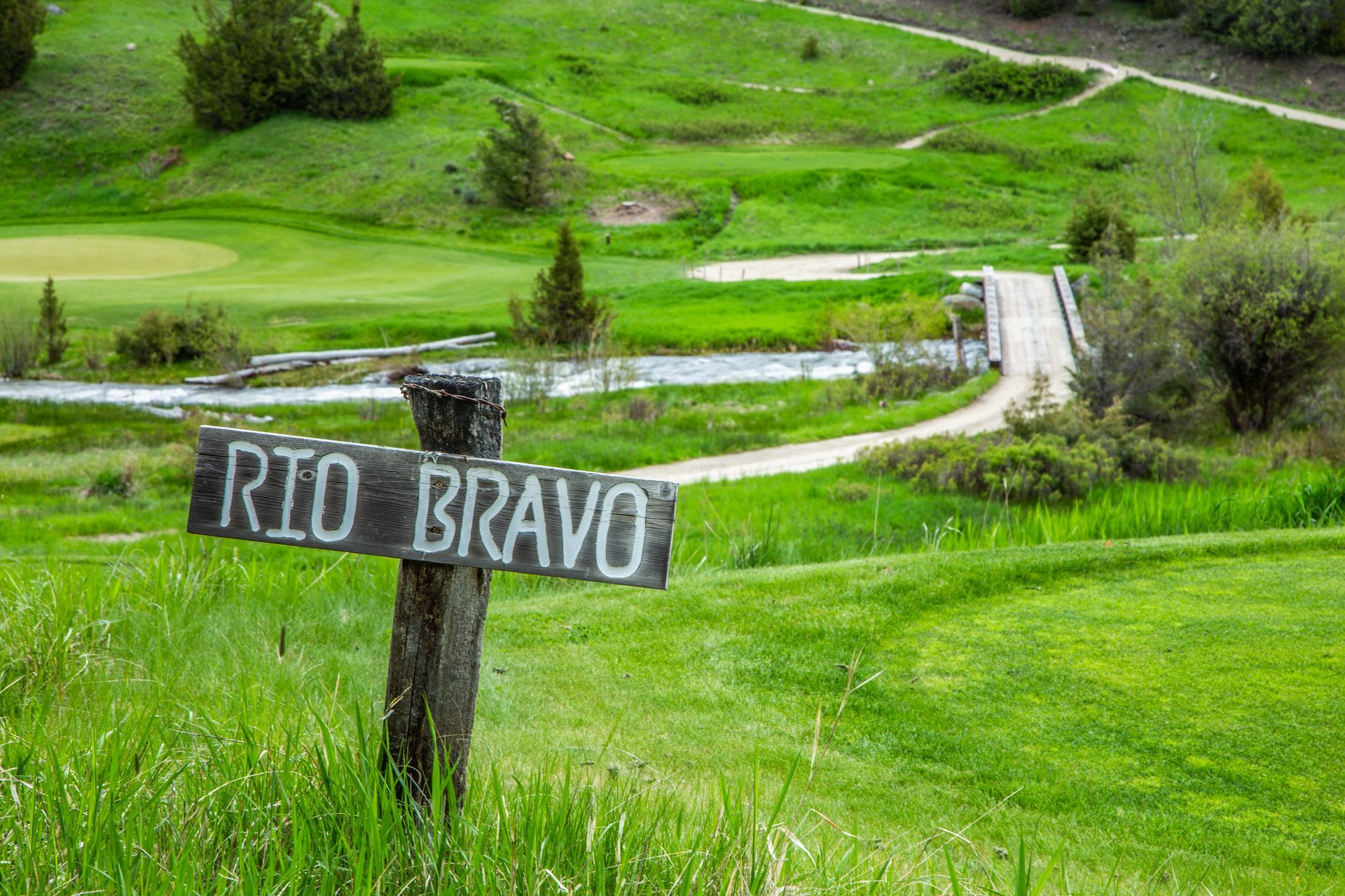 A wooden sign in the middle of a grassy field says rio bravo.