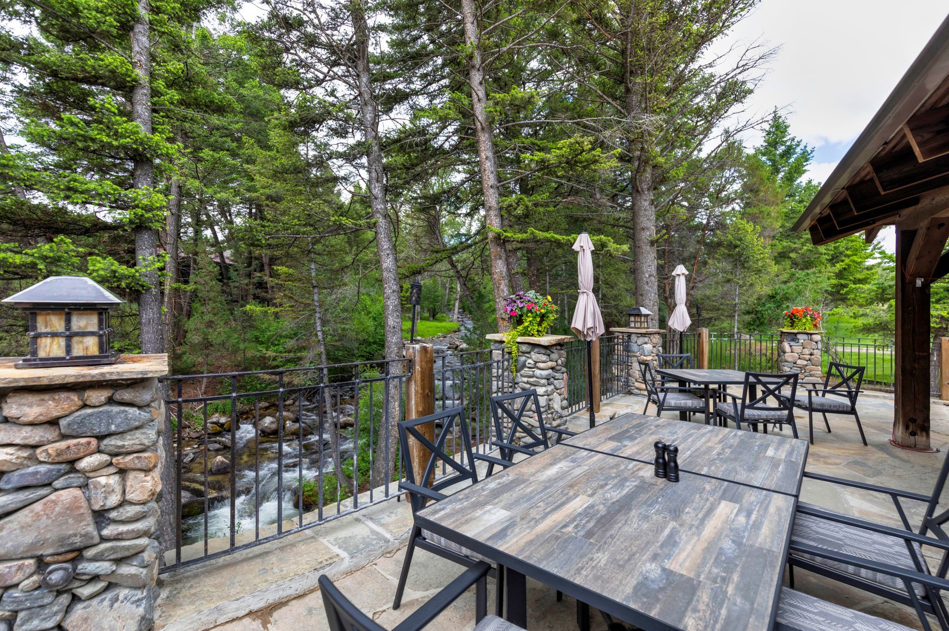 There is a table and chairs on the patio with a river in the background.